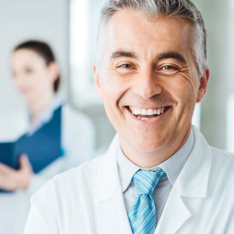 Smiling LASIK doctor in a white lab coat